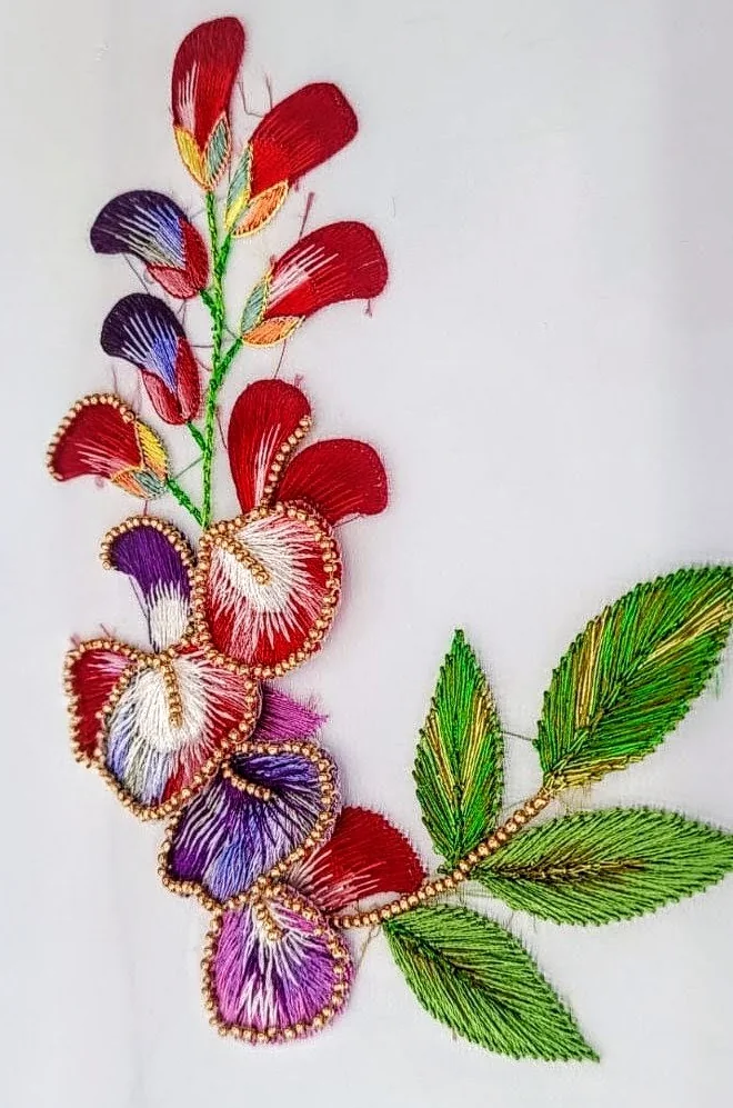 Red and purple stitched flowers with bright green leaves and clearly visible thread direction.
