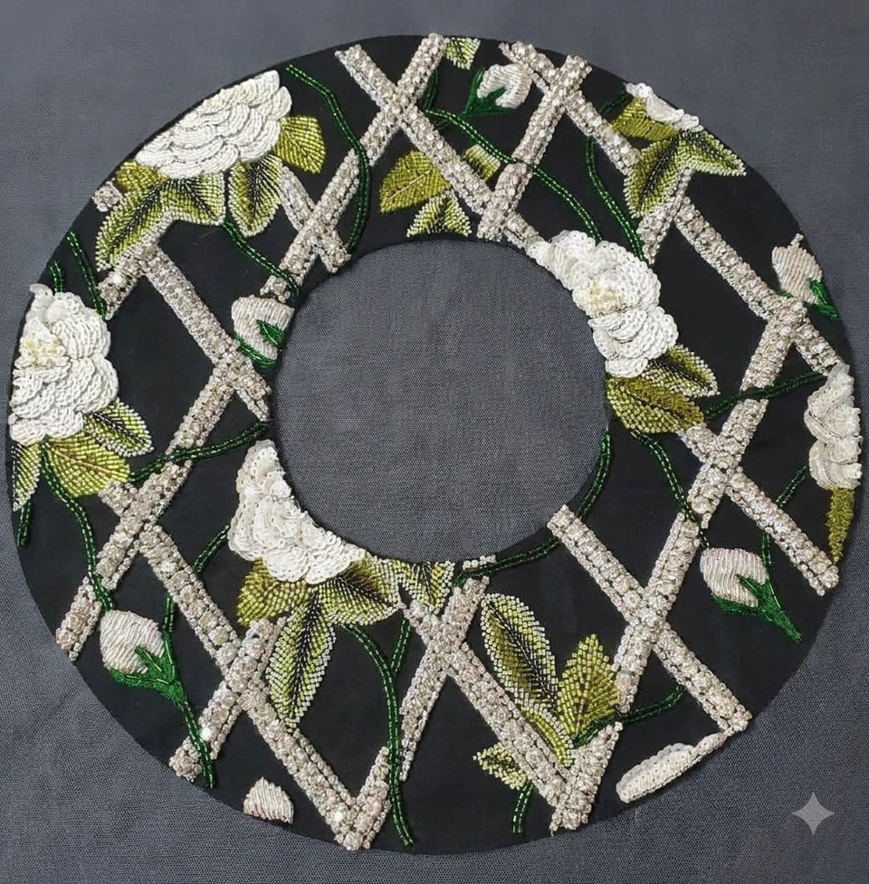 Circular black neckline panel with white floral embroidery, green leaves and a pale diagonal lattice.